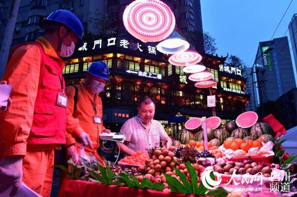 国网四川电力（成都城西）连心桥共产党员服务队队员正在摊位前了解用电情况。 国网成都供电公司供图
